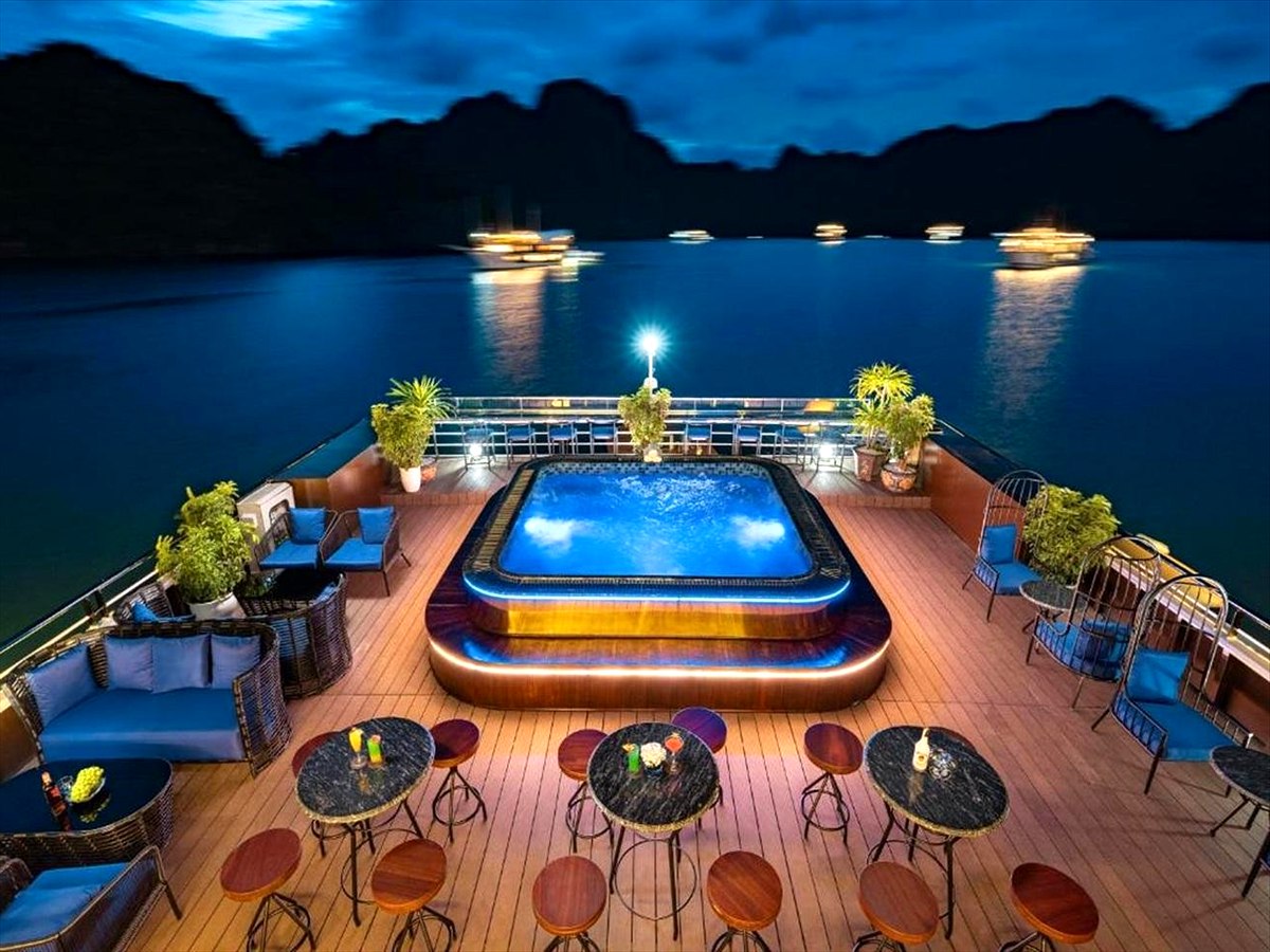Solarium con piscina illuminata di sera su una crociera nella baia di Lan Ha